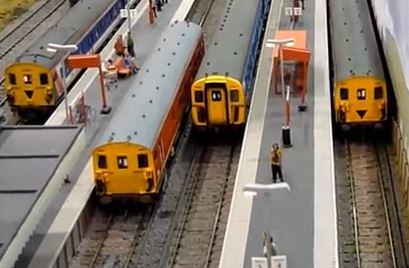 HO model trains at train station platforms